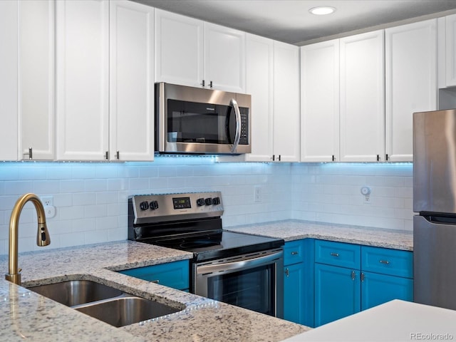 kitchen featuring blue cabinetry, appliances with stainless steel finishes, sink, and white cabinets