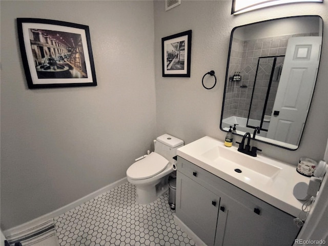 bathroom featuring vanity, tile patterned flooring, toilet, and a tile shower