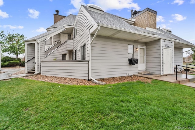 17004 E Tennessee Dr Unit 103, Aurora, CO 80017 - view of side of home with a chimney, a yard, and roof with shingles