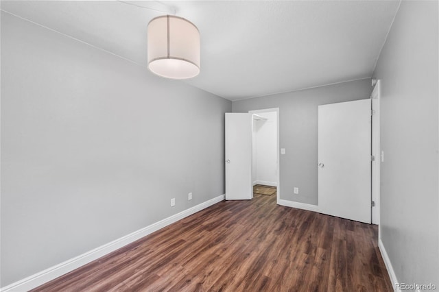 17004 E Tennessee Dr Unit 103, Aurora, CO 80017 - unfurnished bedroom featuring wood finished floors, baseboards, a spacious closet, and a closet