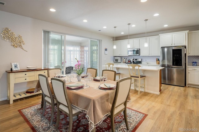 dining space with light hardwood / wood-style flooring