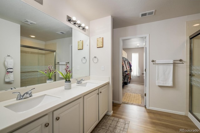 bathroom with vanity, a shower with door, and hardwood / wood-style floors