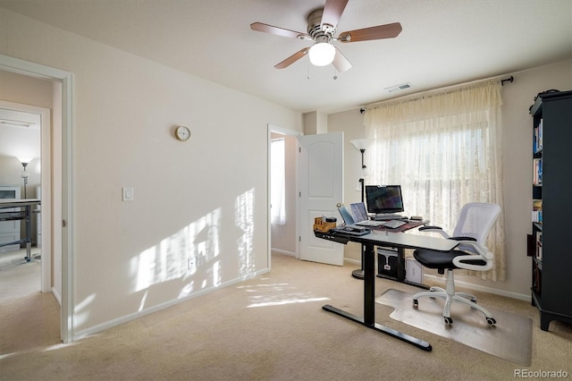 carpeted office featuring ceiling fan