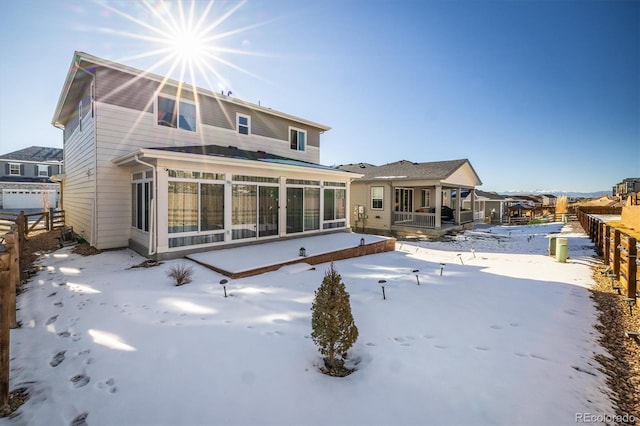 snow covered property featuring a sunroom