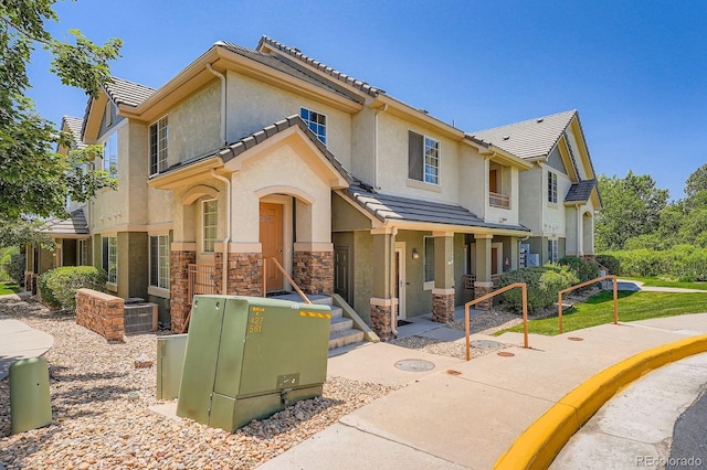22560 E Ontario Dr Unit 204, Aurora, CO 80016 - view of front of home with stone siding, stucco siding, and a tiled roof