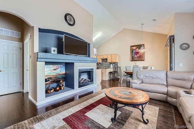 22560 E Ontario Dr Unit 204, Aurora, CO 80016 - living room with a glass covered fireplace, dark wood finished floors, vaulted ceiling, and arched walkways
