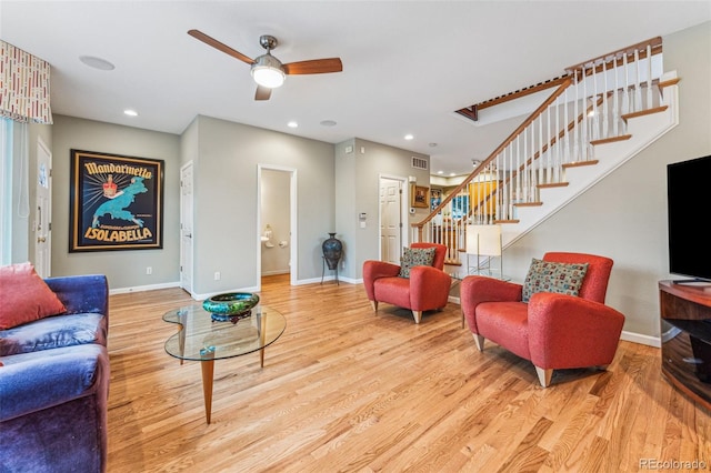 living area with stairway, baseboards, and wood finished floors