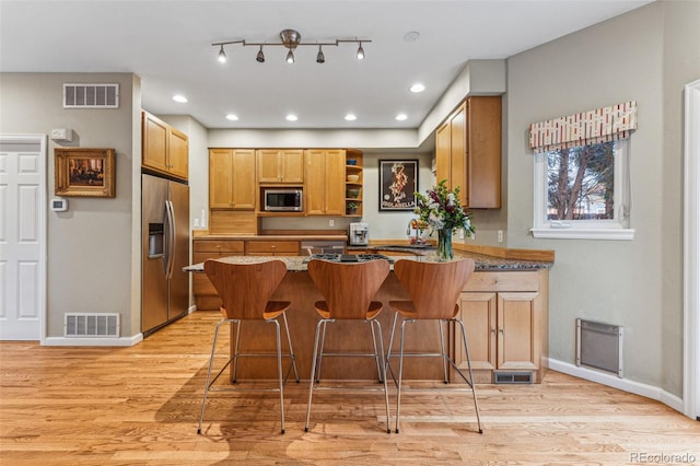 kitchen featuring visible vents, light wood finished floors, and stainless steel appliances