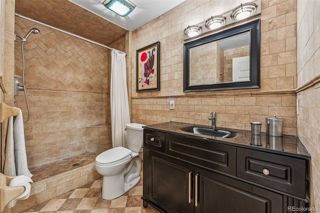 full bath featuring vanity, tile walls, toilet, and a tile shower