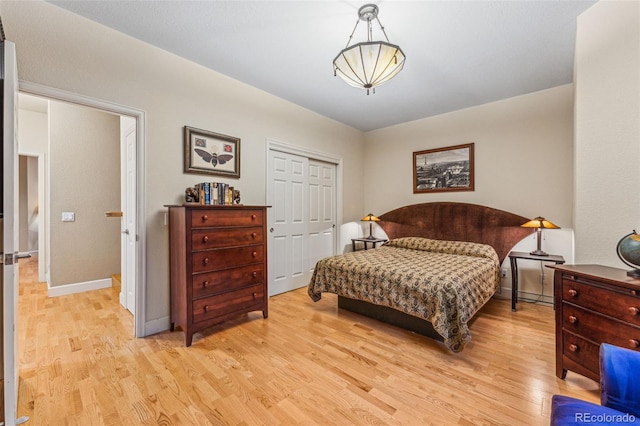 bedroom featuring a closet, baseboards, and light wood finished floors