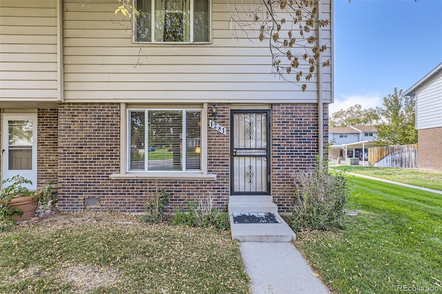 entrance to property featuring a lawn