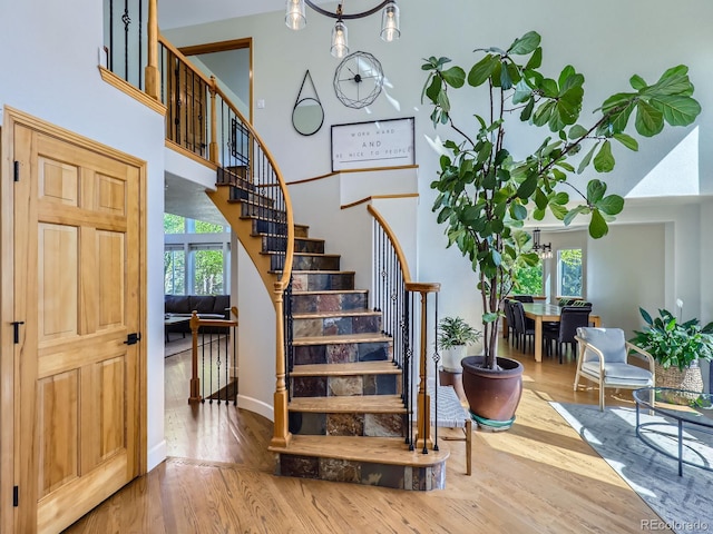 6366 Umber Cir, Arvada, CO 80403 - stairs with wood finished floors, plenty of natural light, a towering ceiling, and baseboards