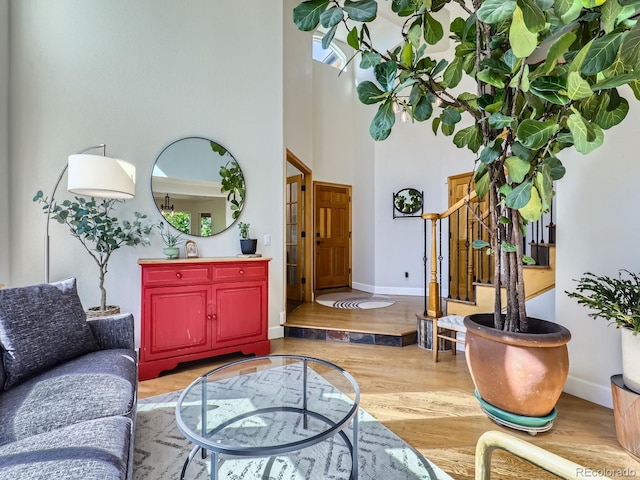 6366 Umber Cir, Arvada, CO 80403 - living room featuring wood finished floors, stairway, a high ceiling, and baseboards