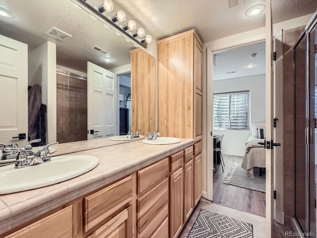 6366 Umber Cir, Arvada, CO 80403 - ensuite bathroom featuring a stall shower, a textured ceiling, and double vanity