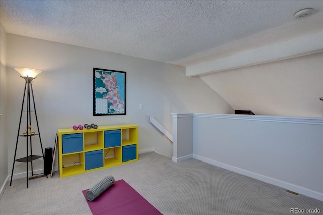 exercise area featuring baseboards, vaulted ceiling, carpet, and a textured ceiling