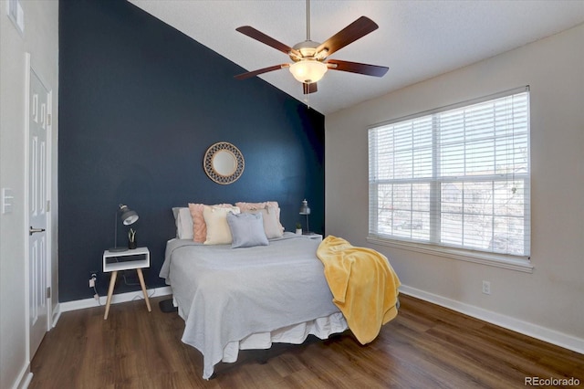 bedroom featuring baseboards, vaulted ceiling, wood finished floors, and ceiling fan