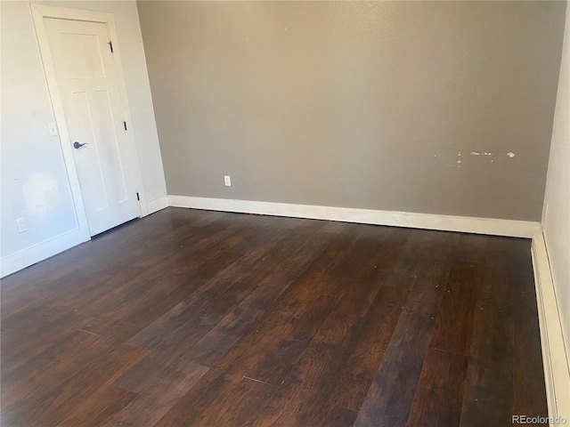 empty room with dark hardwood / wood-style flooring