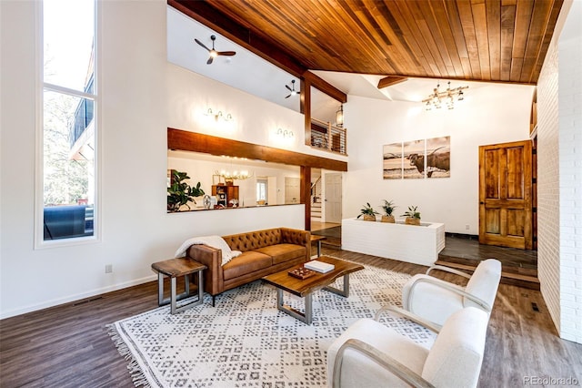 living area featuring high vaulted ceiling, wood finished floors, a wealth of natural light, and a notable chandelier