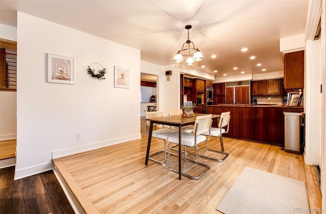 dining space featuring an inviting chandelier, light wood-style flooring, baseboards, and recessed lighting