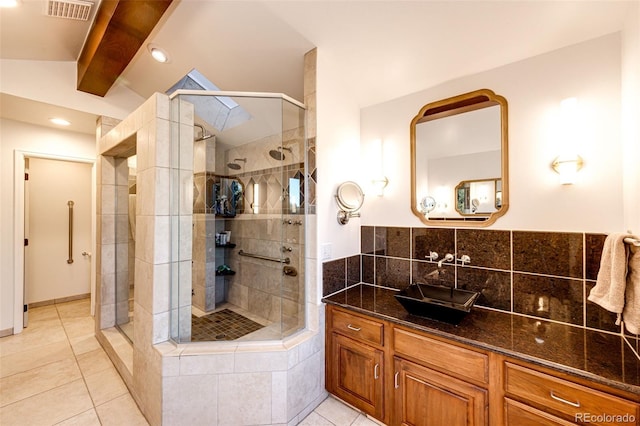 full bathroom with vaulted ceiling, a stall shower, tile patterned flooring, and visible vents