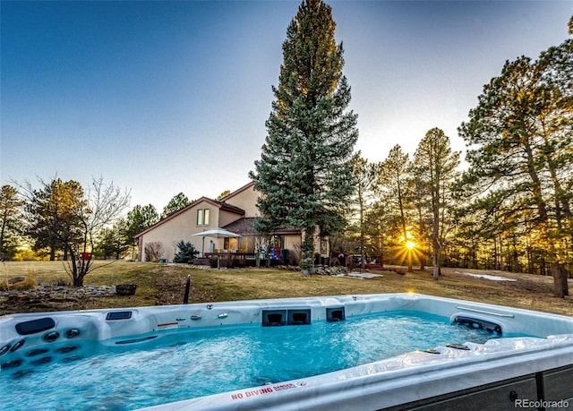 view of pool featuring a yard and a hot tub