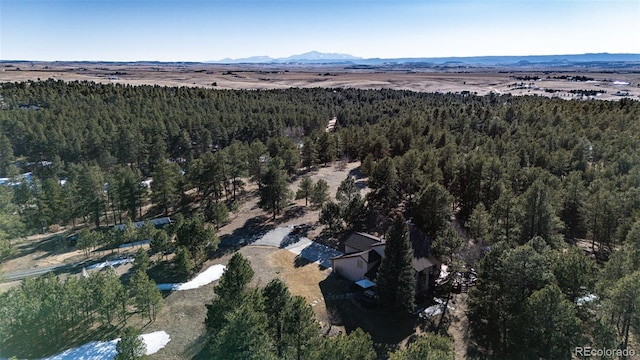 birds eye view of property featuring a mountain view and a wooded view