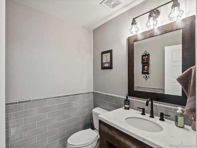 280 E 11th Ave, Broomfield, CO 80020 - half bath featuring vanity, tile walls, and a wainscoted wall