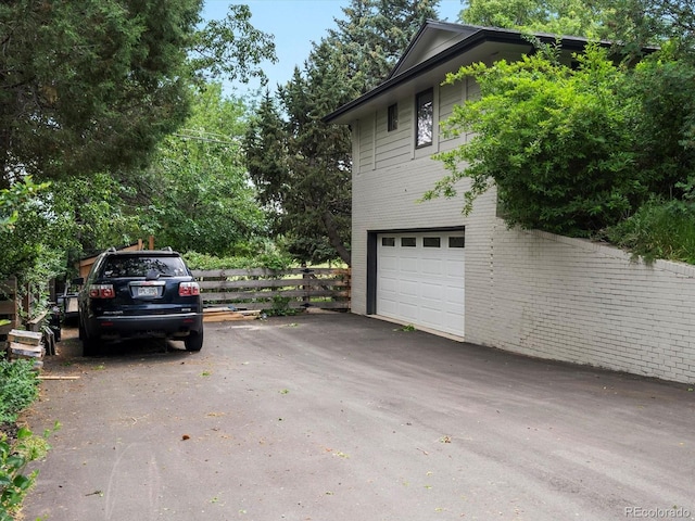 280 E 11th Ave, Broomfield, CO 80020 - view of home's exterior featuring an attached garage, brick siding, and asphalt driveway