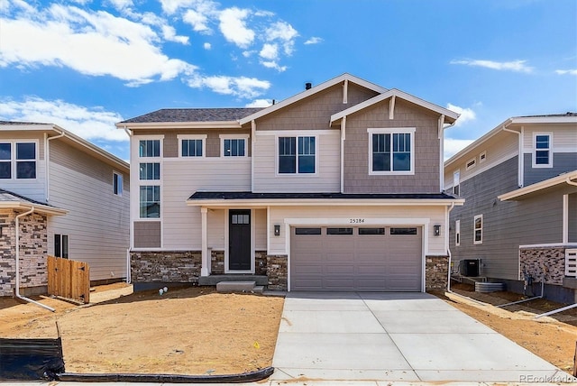 25284 E Warren Pl, Aurora, CO 80018 - view of front of home featuring driveway, stone siding, and a garage