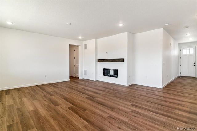 25284 E Warren Pl, Aurora, CO 80018 - unfurnished living room with wood finished floors, recessed lighting, and a glass covered fireplace