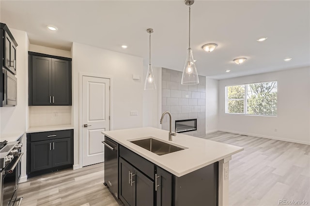 kitchen featuring sink, stainless steel appliances, decorative light fixtures, decorative backsplash, and a kitchen island with sink