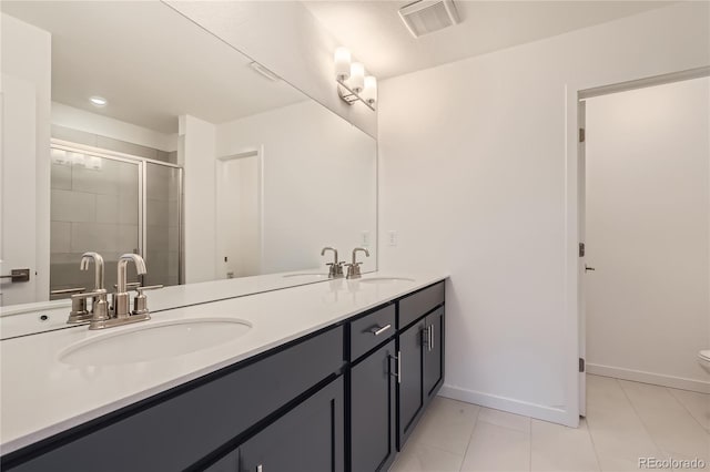 bathroom featuring toilet, a shower with door, vanity, and tile patterned floors