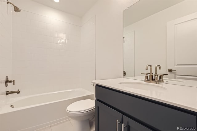 full bathroom featuring tiled shower / bath, vanity, tile patterned floors, and toilet