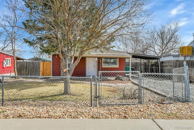 view of front of house with a fenced front yard, a carport, and a gate