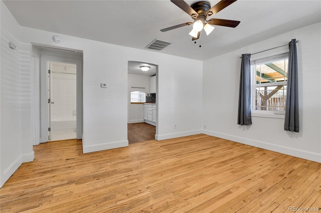unfurnished bedroom with visible vents, light wood-style flooring, a ceiling fan, ensuite bath, and baseboards