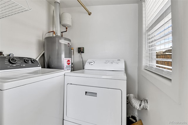 clothes washing area featuring washing machine and clothes dryer, laundry area, and electric water heater
