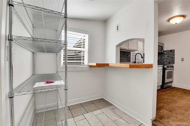 walk in closet with arched walkways and a sink