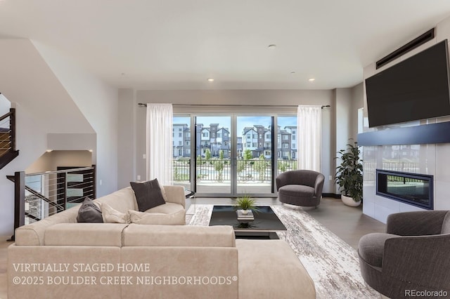 living room with hardwood / wood-style floors, a tile fireplace, and a healthy amount of sunlight