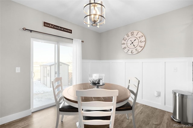 dining space with hardwood / wood-style flooring and a chandelier