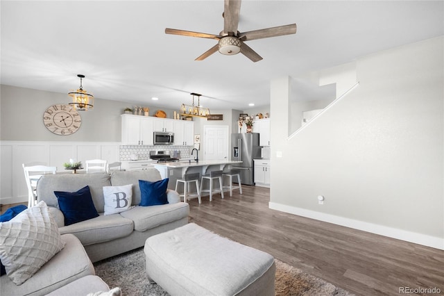 living room with sink, dark hardwood / wood-style floors, and ceiling fan