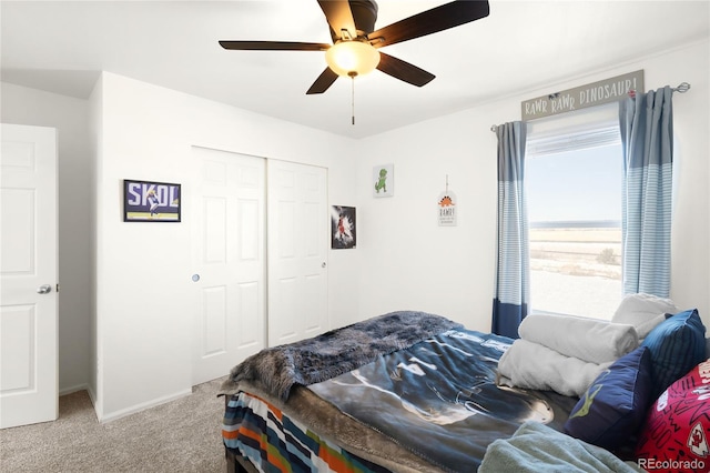 bedroom with light colored carpet, ceiling fan, and a closet