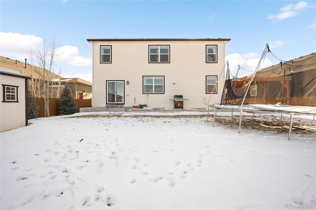 snow covered house with a trampoline