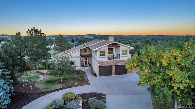 view of front of house featuring concrete driveway, a chimney, and an attached garage