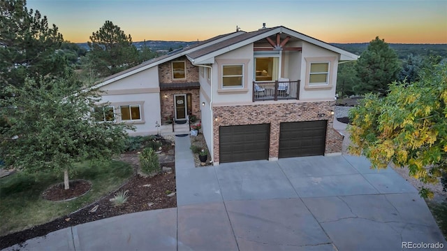 view of front of house with driveway, stucco siding, an attached garage, and brick siding