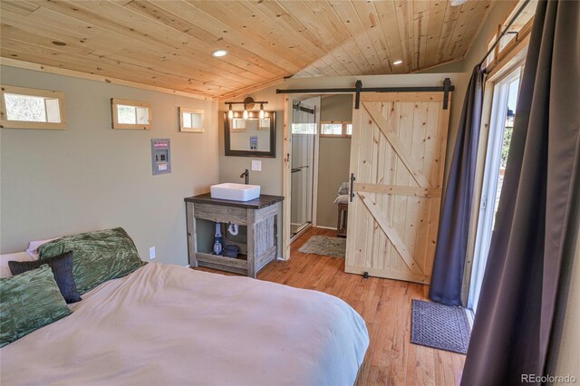 216 Rainbow Ridge Rd, Canon City, CO 81212 - bedroom with vaulted ceiling, wood finished floors, a barn door, multiple windows, and wood ceiling