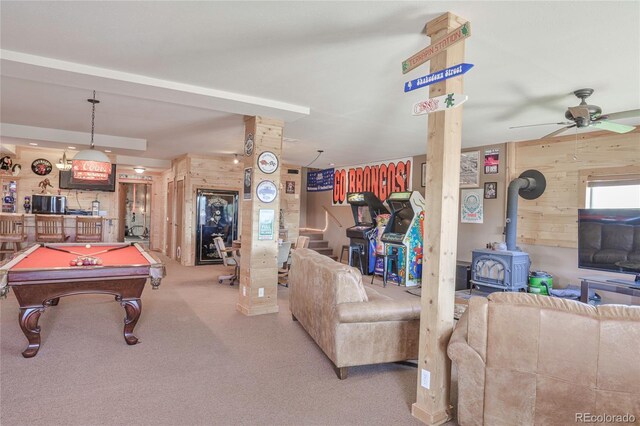 216 Rainbow Ridge Rd, Canon City, CO 81212 - playroom featuring wooden walls, a wood stove, billiards table, a ceiling fan, and carpet flooring