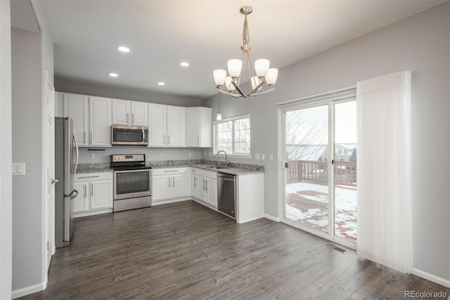 kitchen with dark hardwood / wood-style floors, white cabinetry, sink, hanging light fixtures, and stainless steel appliances