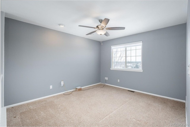 empty room featuring ceiling fan and carpet