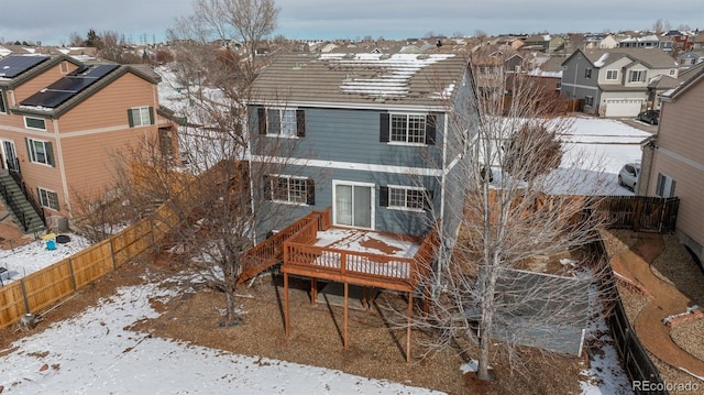 snow covered rear of property featuring a wooden deck