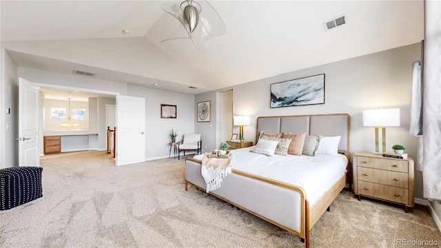 bedroom with light carpet, ensuite bathroom, and lofted ceiling